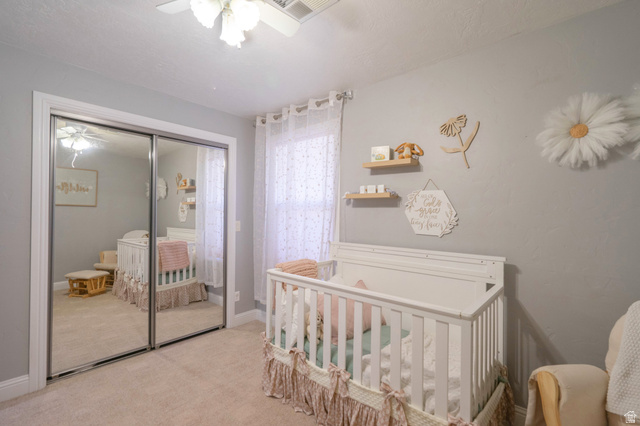 1504 Rome Way Apple Valley, UT 84737 - Photo 16 of 22 Bedroom featuring mirrored sliding closet doors, a ceiling fan with light fixture, carpeted flooring, and a window with sheer curtains