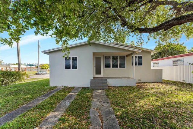 a house with green field in front of it