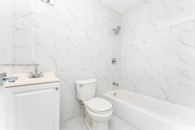 a bathroom with a toilet sink vanity and bathtub