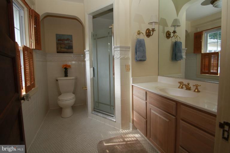 4108 Roland Avenue Baltimore, MD 21211 - Photo 22 of 24 a bathroom with a granite countertop sink toilet and shower