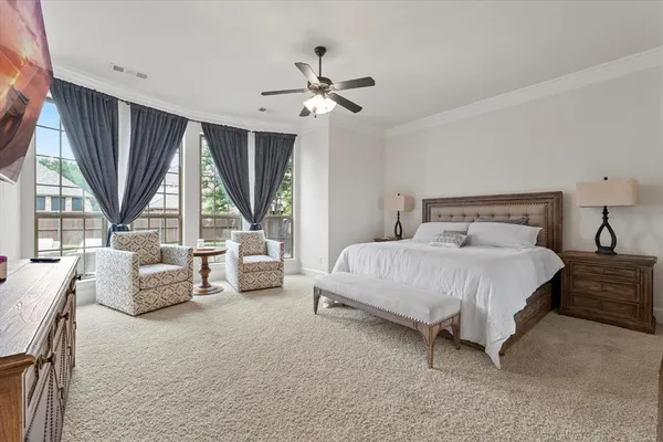a bedroom with furniture and a large window