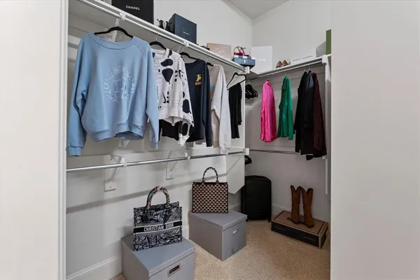 a view of walk in closet with clothes and shoes