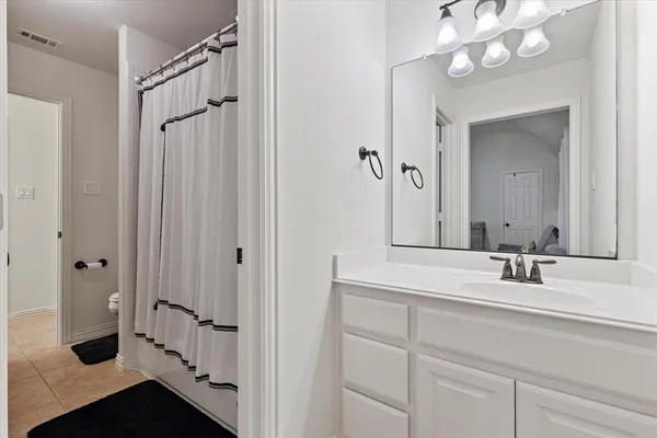 a bathroom with a double vanity sink mirror and shower