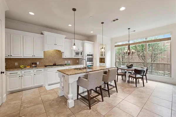 a kitchen with appliances cabinets and chair