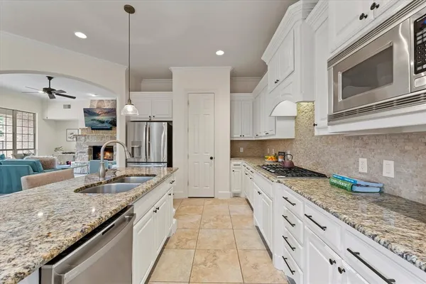 a large kitchen with granite countertop lots of counter space and stainless steel appliances