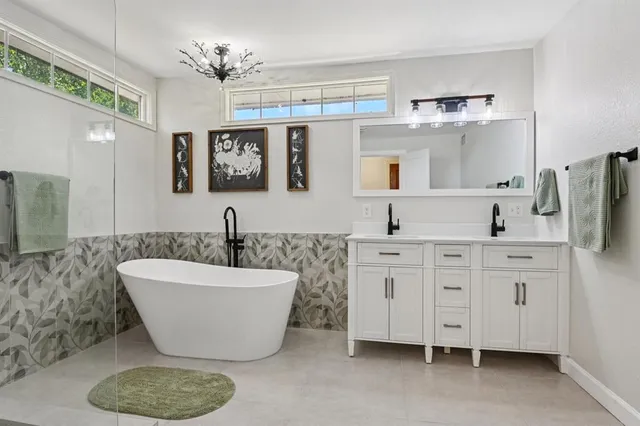 a spacious bathroom with a double vanity sink mirror and bathtub