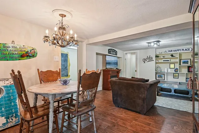 a view of a dining room with furniture a chandelier and wooden floor