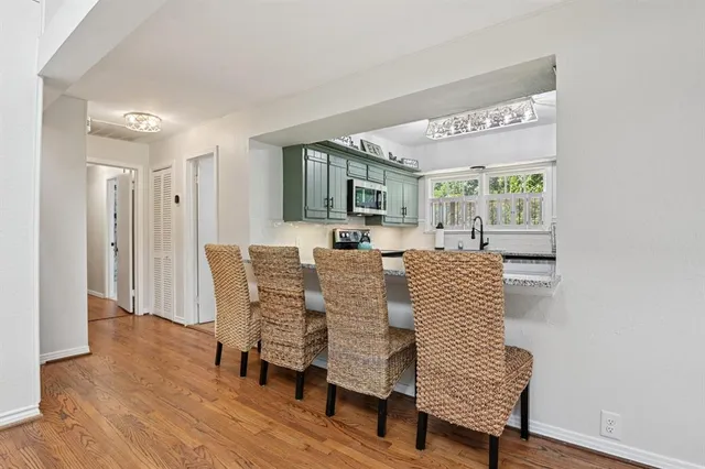 a view of a a dining room with furniture window and wooden floor