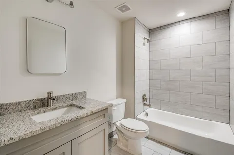 a bathroom with a granite countertop sink toilet and shower