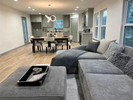 a living room with furniture a large window and kitchen view