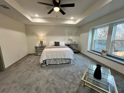 a spacious bedroom with a bed a couch and a window