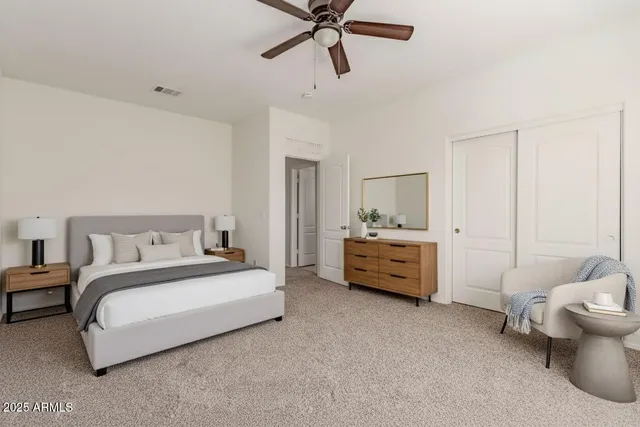 a spacious bedroom with a bed and a chandelier