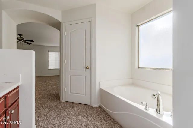 an empty room with closet and a chandelier fan
