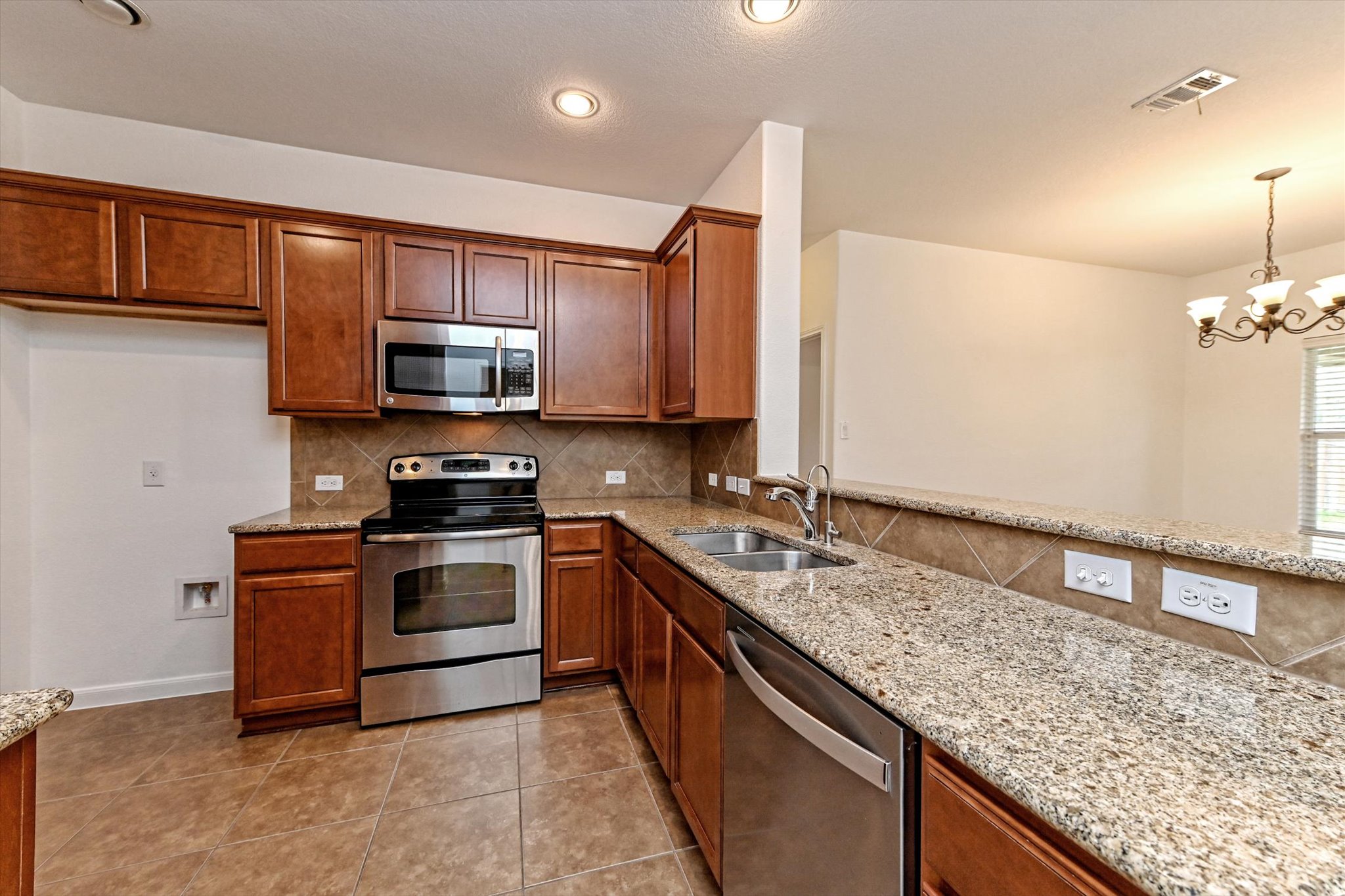 1921 Conn Creek Road Cedar Park, TX 78613 - Photo 13 of 40 a kitchen with stainless steel appliances granite countertop a stove a sink and a microwave
