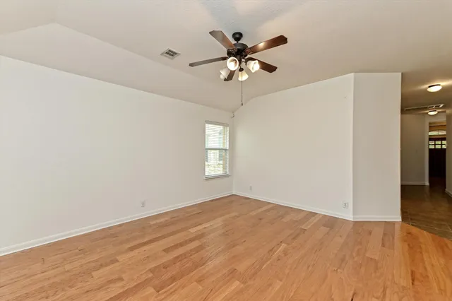 a view of empty room with wooden floor