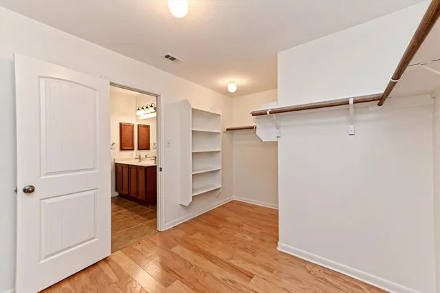 a view of walk in closet with wooden floor