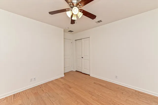 an empty room with a ceiling fan and a window