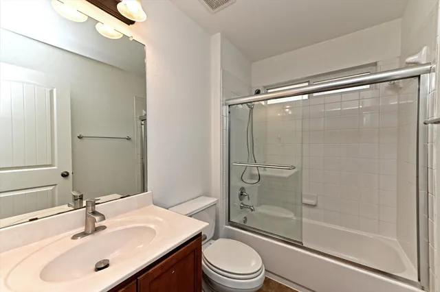 a bathroom with a sink mirror shower and toilet