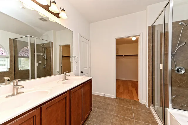 a bathroom with a double vanity sink a mirror and a shower