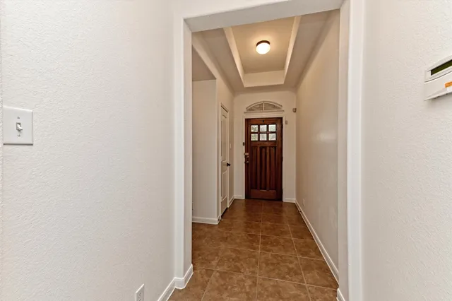 a view of a hallway with wooden floor and mirror