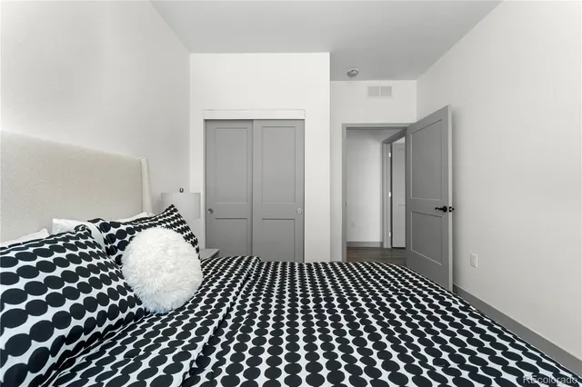 a bedroom with a bed wooden floor and a window