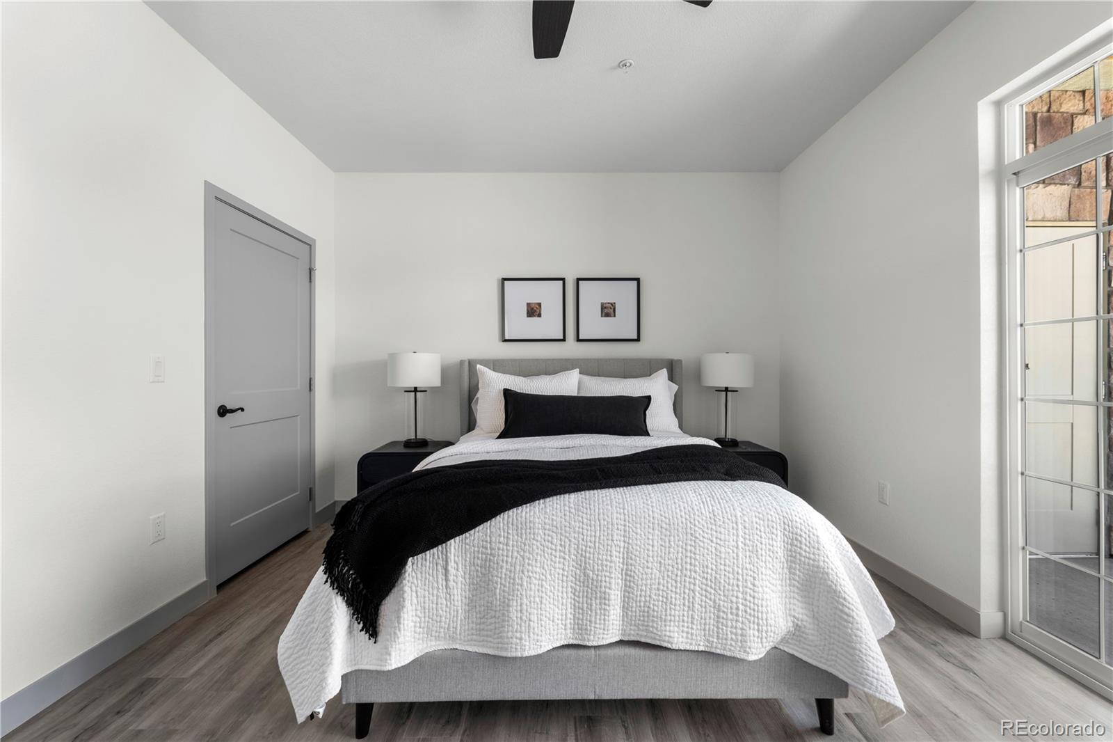 18645 Stroh Road, Unit 2208 Parker, CO 80134 - Photo 25 of 32 a bedroom with a bed and wooden floor
