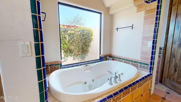 a spacious bathroom with a tub sink and mirror