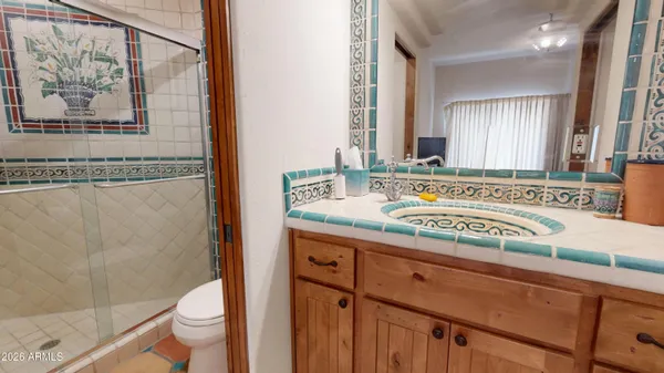 a bathroom with a granite countertop sink mirror vanity and toilet