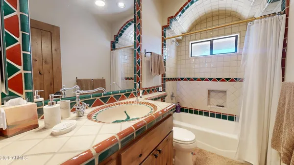 a bathroom with a granite countertop sink a mirror and a bathtub