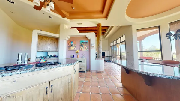 a living room with stainless steel appliances kitchen island granite countertop furniture and a large window