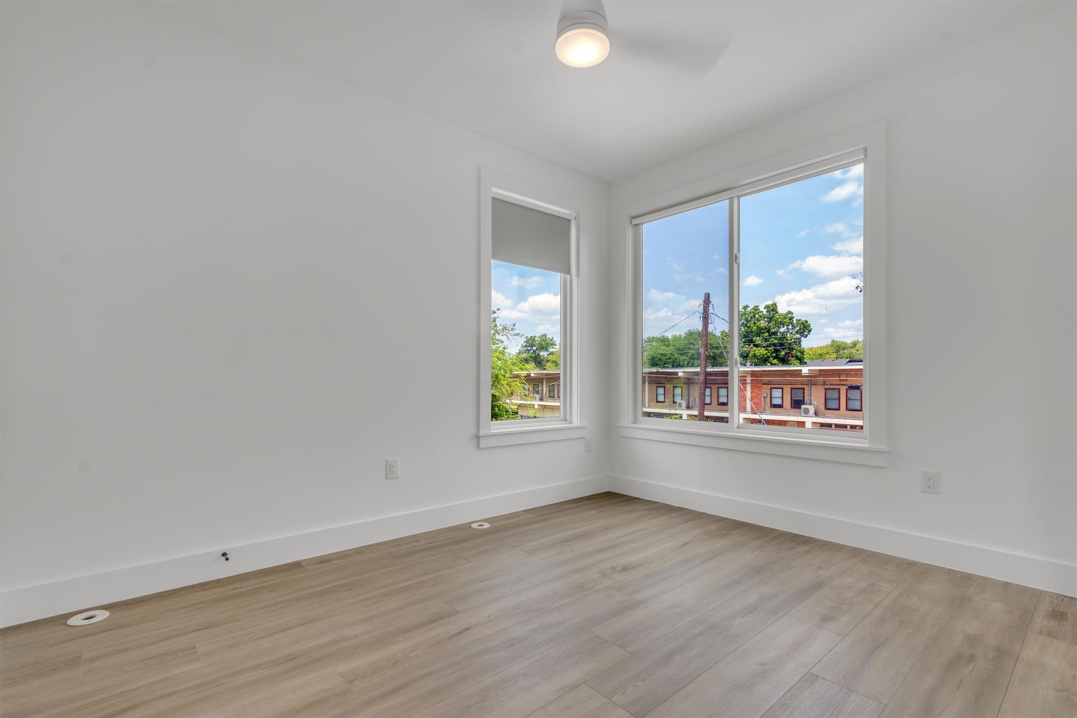 3101 Lyons Road Austin, TX 78702 - Photo 23 of 40 A well-lit bedroom features durable plank flooring and views of the surrounding neighborhood.