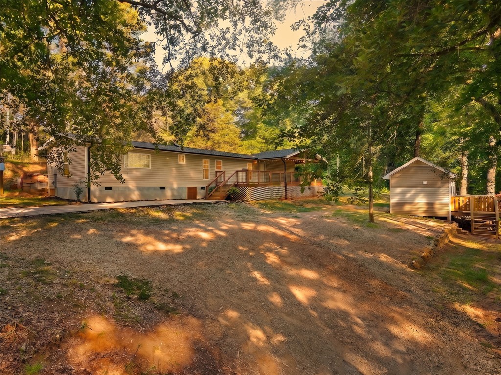 217 Old River Road Pelzer, SC 29669 - Photo 33 of 34 Mature trees shade a spacious property featuring an elevated wooden deck and detached storage building.