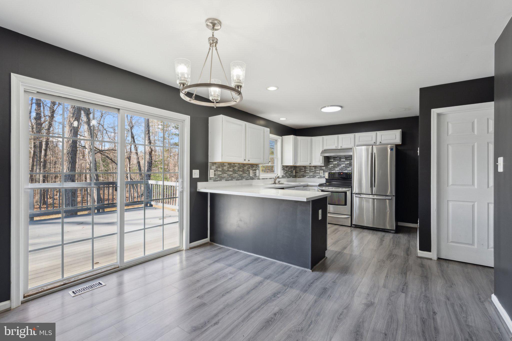6169 Vance Lane Culpeper, VA 22701 - Photo 7 of 44 a kitchen with stainless steel appliances granite countertop a refrigerator a sink dishwasher a stove and white countertops with wooden floor