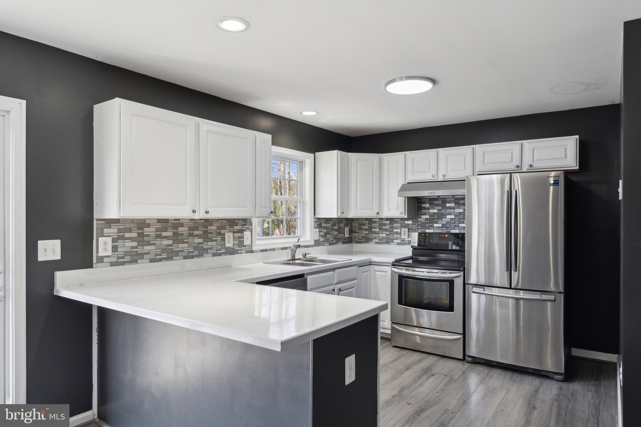 6169 Vance Lane Culpeper, VA 22701 - Photo 8 of 44 a kitchen with a refrigerator a stove top oven a sink and cabinets
