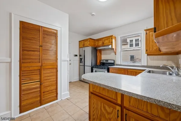 a kitchen with stainless steel appliances granite countertop a sink and a refrigerator