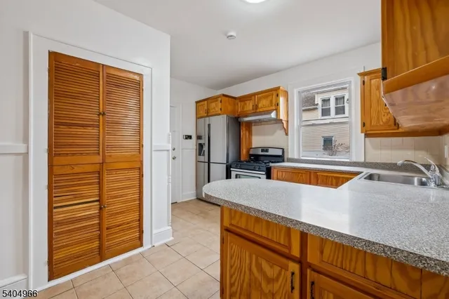 a kitchen with stainless steel appliances granite countertop a sink and a refrigerator