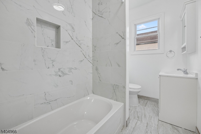 167 Silver Avenue, Unit 2 Hillside, NJ 07205 - Photo 5 of 12 a bathroom with a sink a toilet and shower