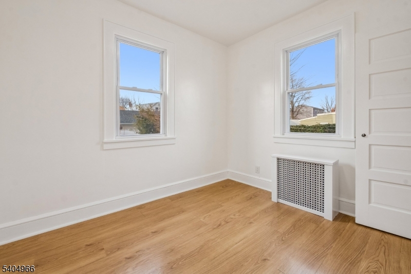 167 Silver Avenue, Unit 2 Hillside, NJ 07205 - Photo 8 of 12 an empty room with wooden floor and windows