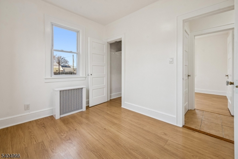 167 Silver Avenue, Unit 2 Hillside, NJ 07205 - Photo 9 of 12 an empty room with wooden floor and windows
