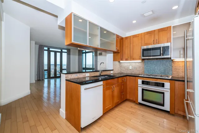 a kitchen with stainless steel appliances granite countertop a stove a sink and a microwave