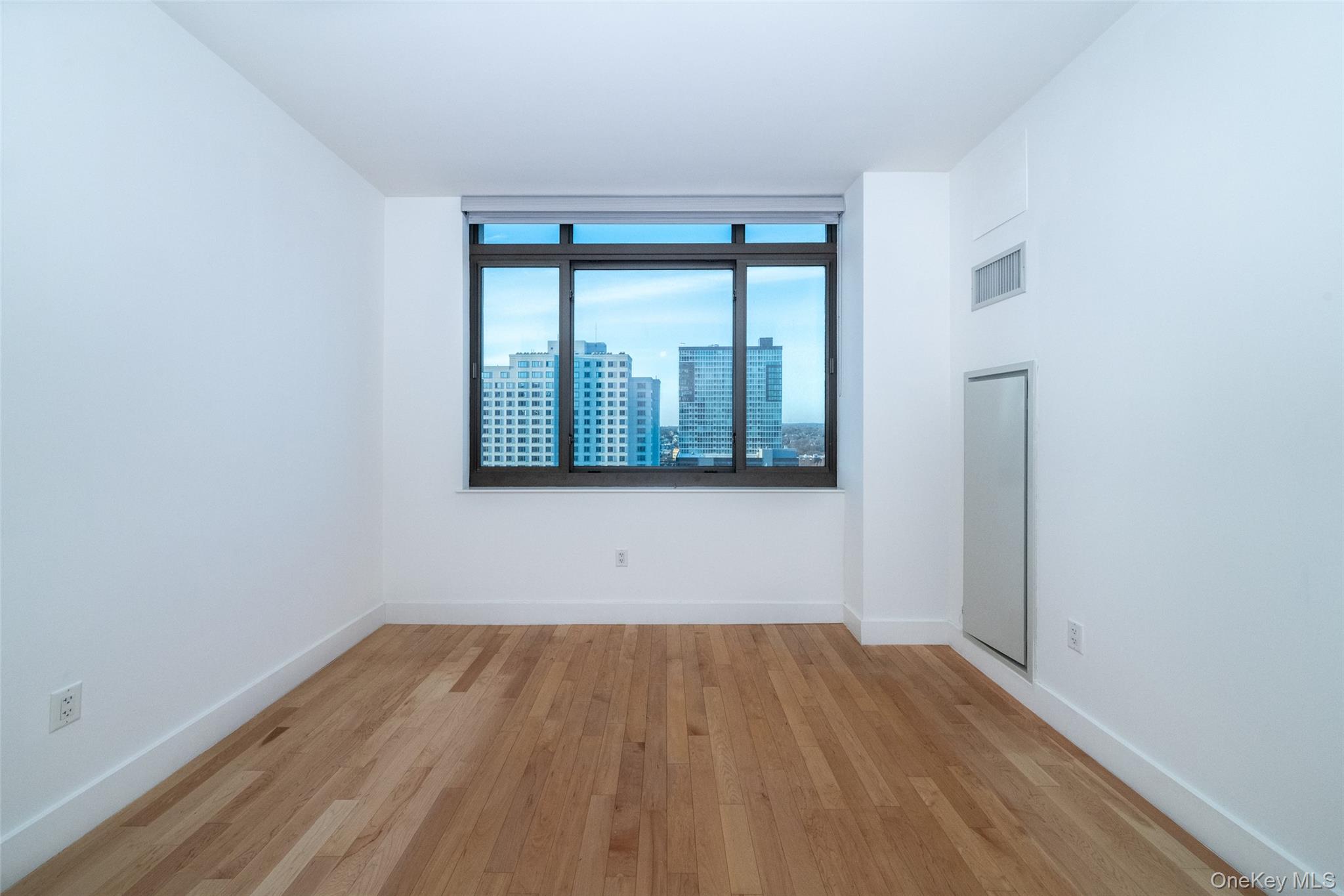 175 Huguenot Street, Unit 1401 New Rochelle, NY 10801 - Photo 13 of 29 wooden floor in an empty room with a window