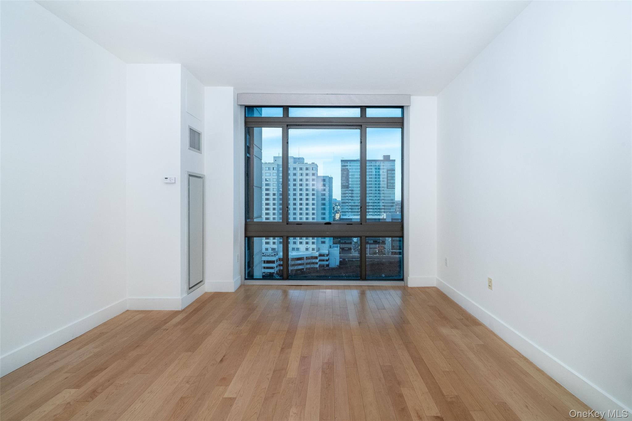 175 Huguenot Street, Unit 1401 New Rochelle, NY 10801 - Photo 20 of 29 a view of a room with wooden floor and a window
