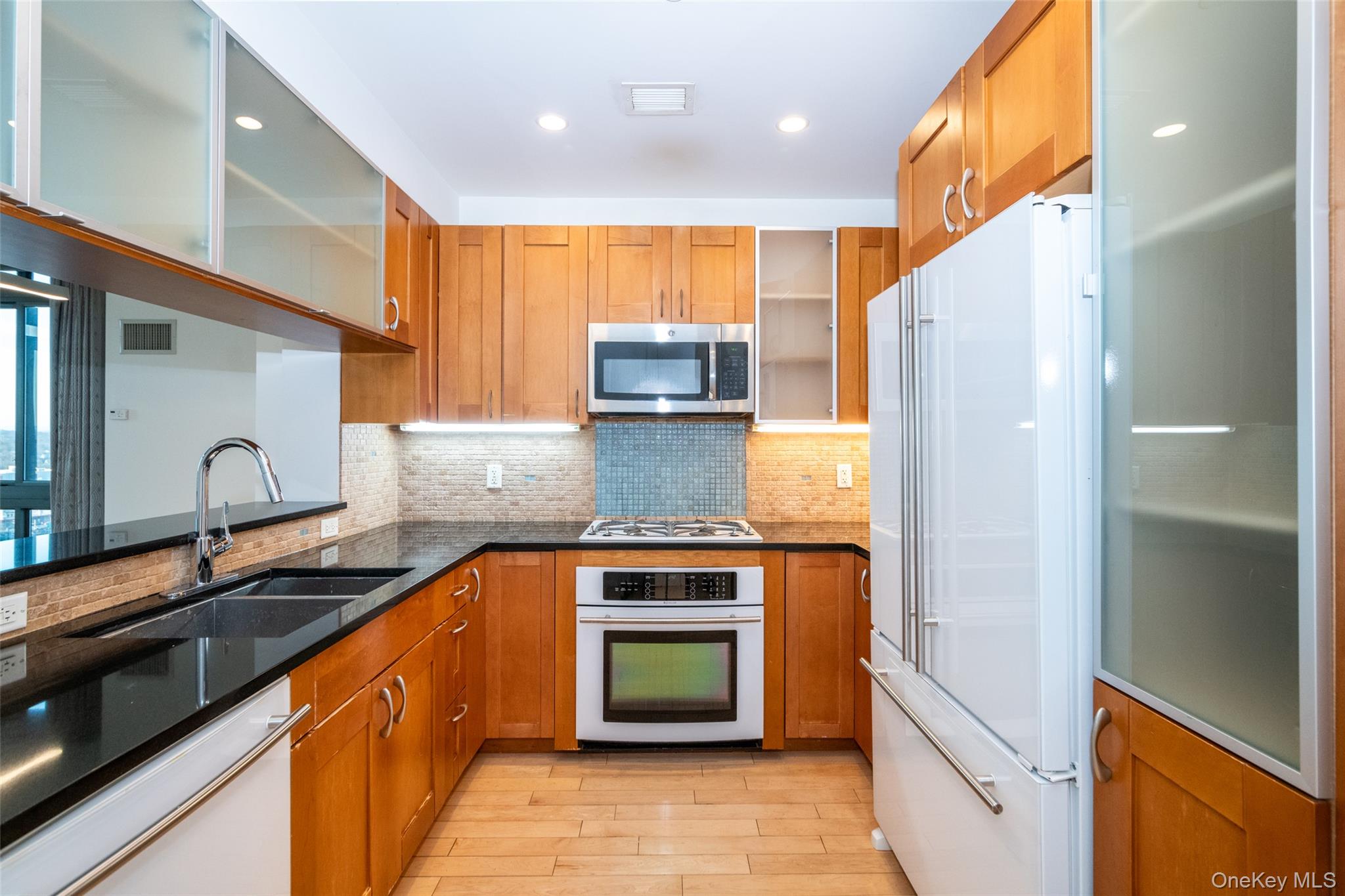 175 Huguenot Street, Unit 1401 New Rochelle, NY 10801 - Photo 2 of 29 a kitchen with stainless steel appliances granite countertop a stove a sink and a refrigerator