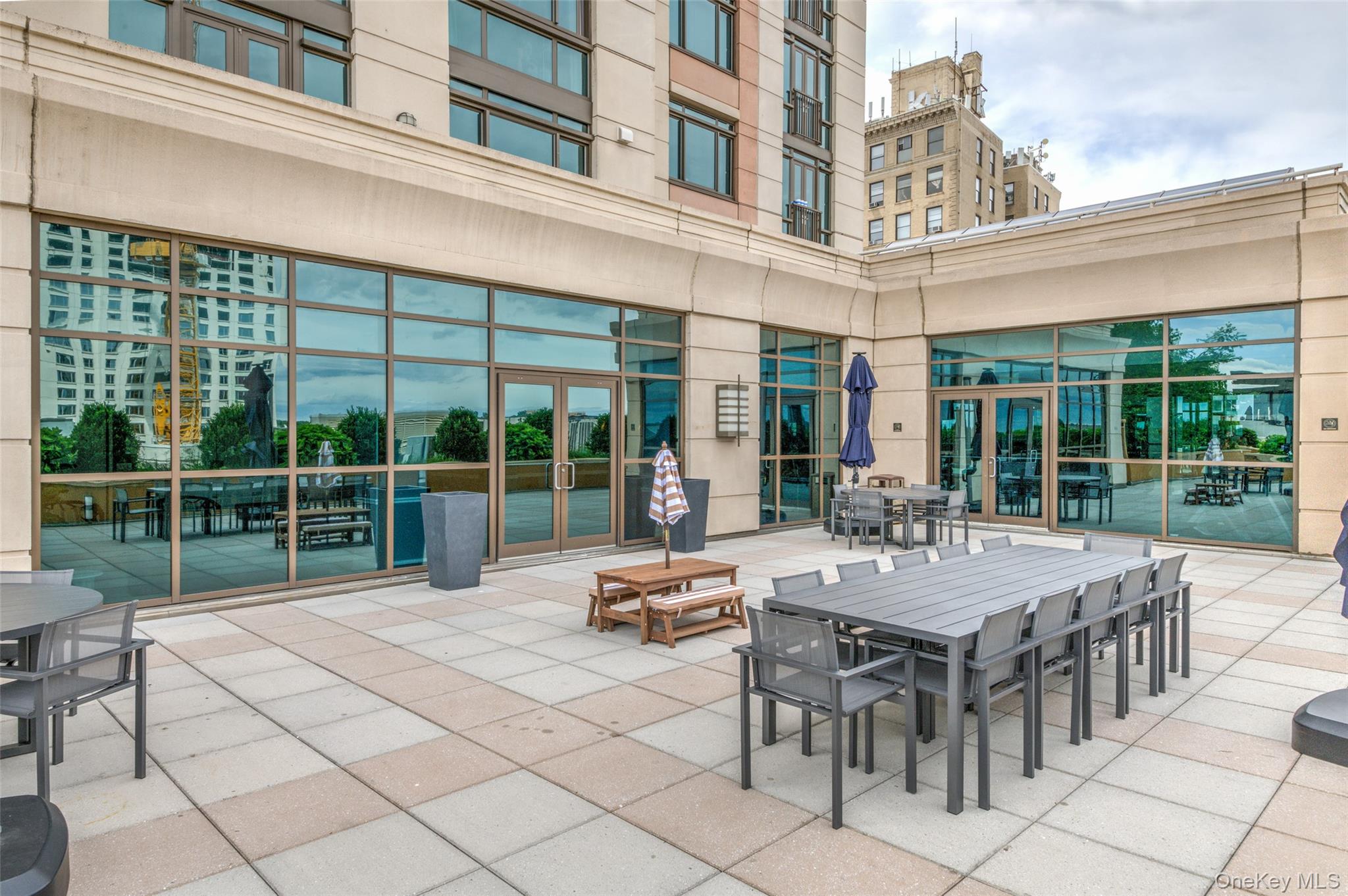 175 Huguenot Street, Unit 1401 New Rochelle, NY 10801 - Photo 25 of 29 a view of a building with a table and chairs