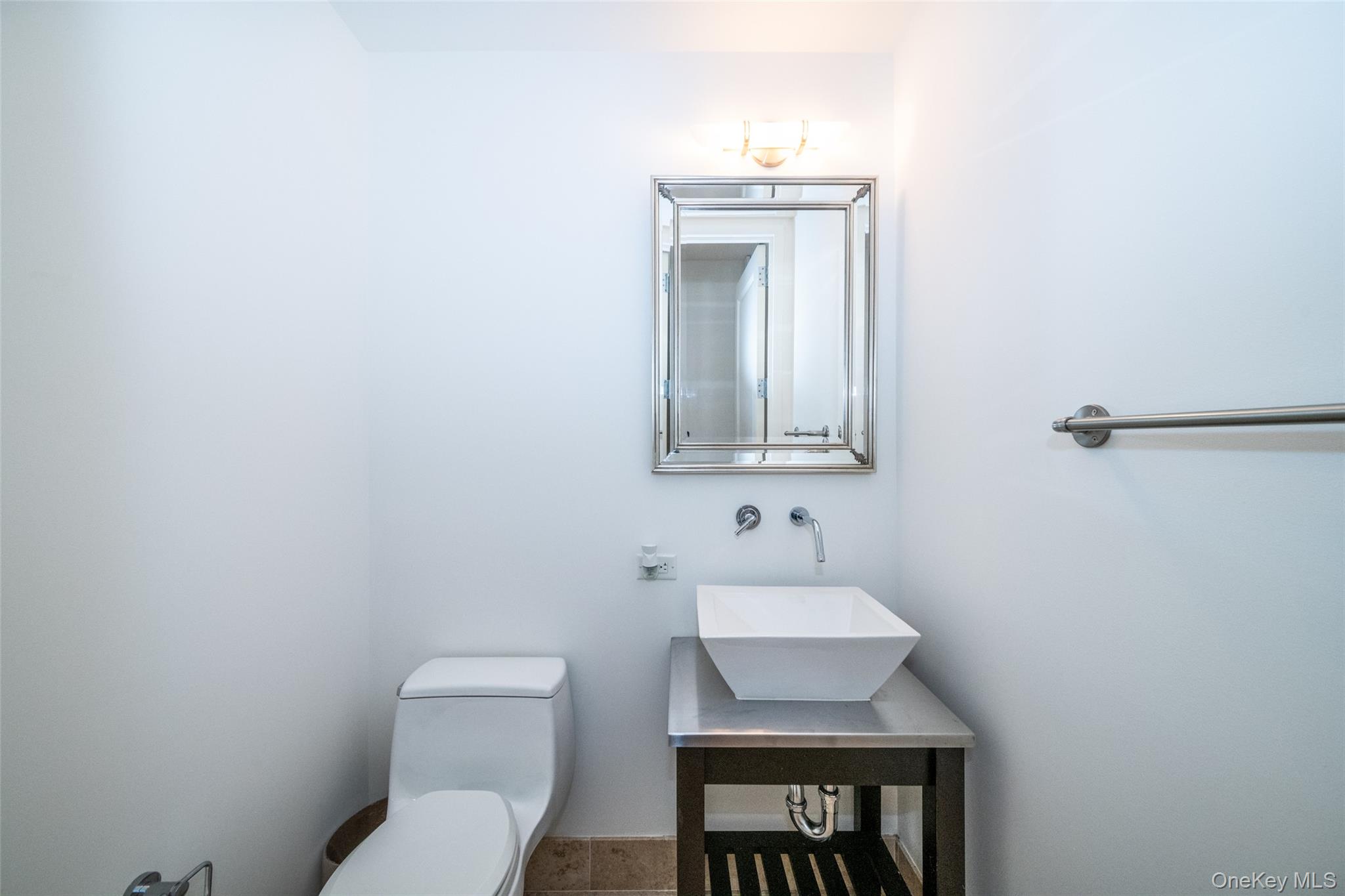 175 Huguenot Street, Unit 1401 New Rochelle, NY 10801 - Photo 5 of 29 a bathroom with a toilet sink and mirror