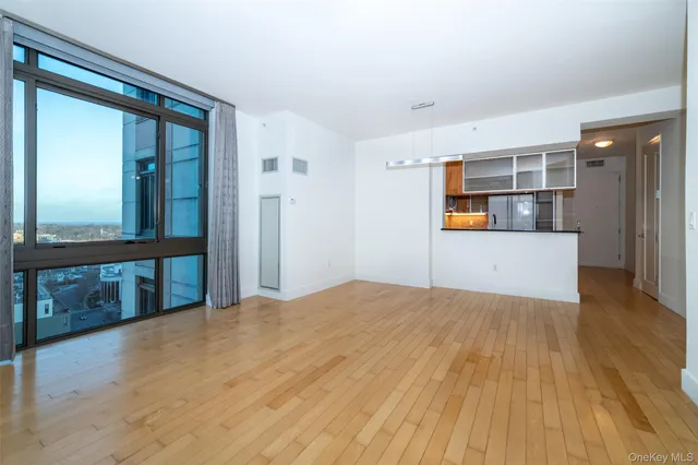 a view of a big room with wooden floor and windows