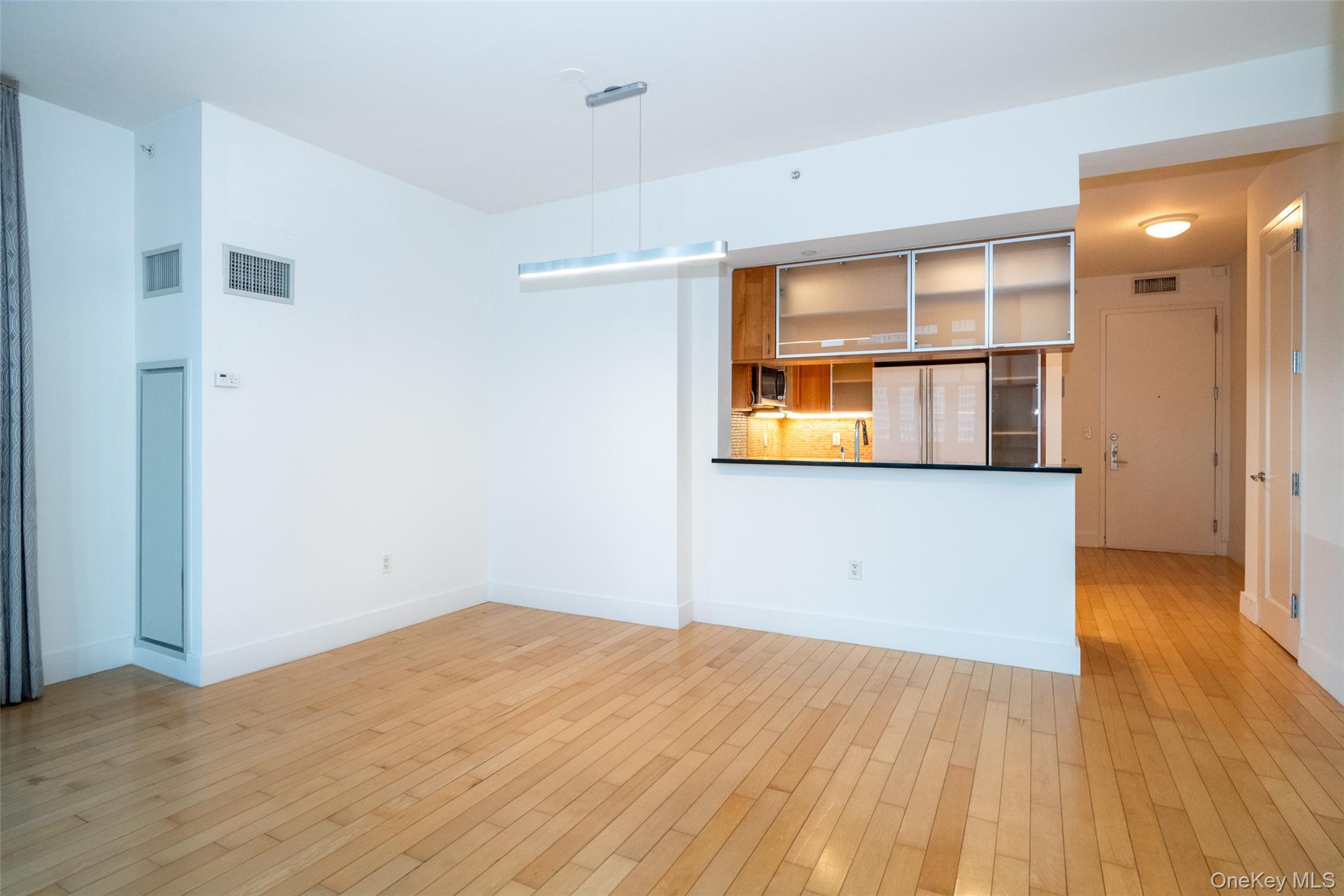175 Huguenot Street, Unit 1401 New Rochelle, NY 10801 - Photo 8 of 29 a view of a room with wooden floor and a window