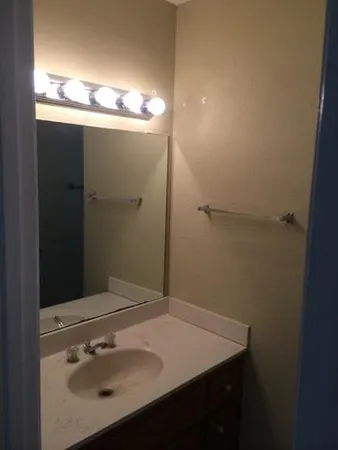 a bathroom with a sink vanity and a mirror
