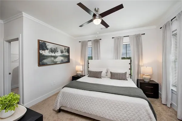 a bedroom with a bed painting on wall and a potted plant