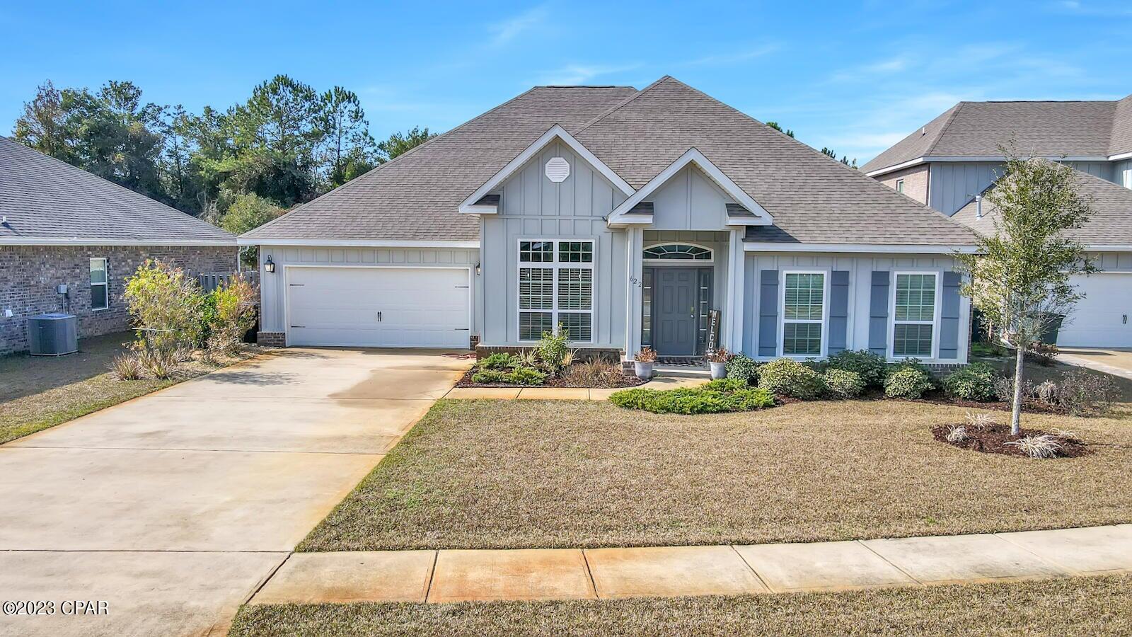 a front view of a house with garden and plants